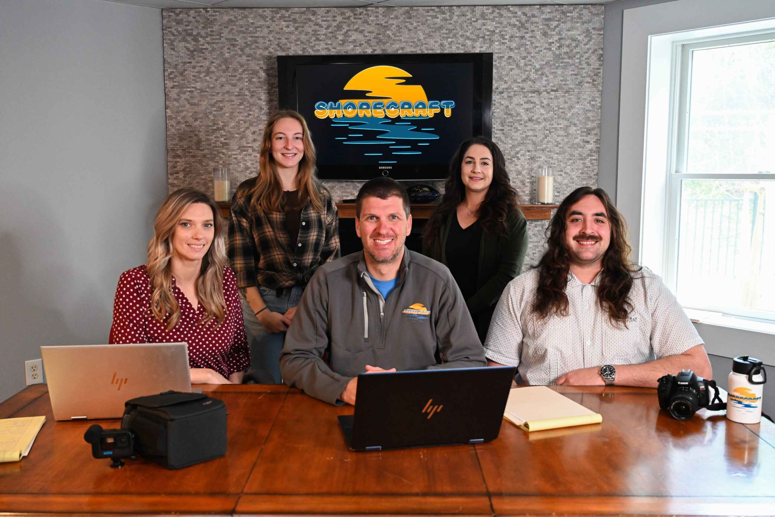 a group of people sitting at a table with laptops